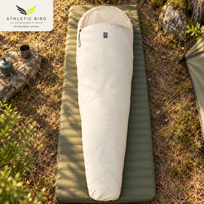 Drap de sac coton sarcophage Wilsa Outdoor déployé sur un matelas de camping en pleine nature, avec logo Athletic Bird