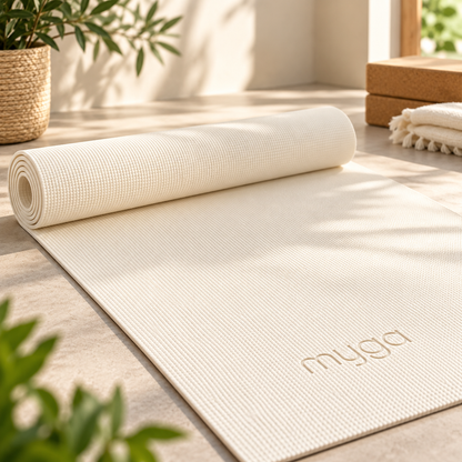 Sportive réalisant une posture de yoga sur le tapis Myga crème antidérapant dans un intérieur lumineux.